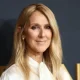 Celine Dion smiling on a red carpet.
