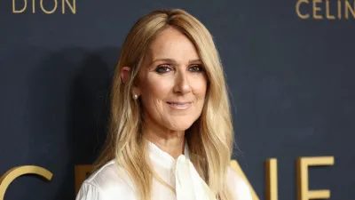 Celine Dion smiling on a red carpet.