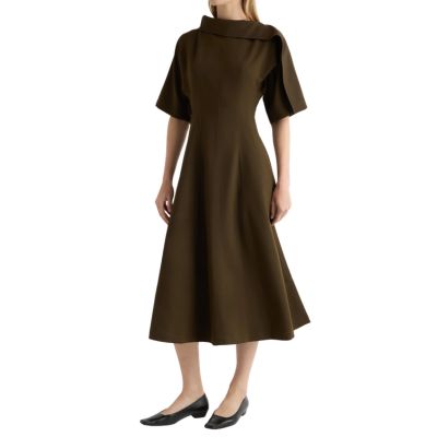 A woman wearing a brown midi dress and black flats