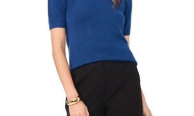 A woman wearing a medium blue short-sleeved sweater and black pants