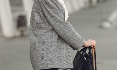 annoyed professional woman stands outside airport with her luggage