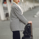 annoyed professional woman stands outside airport with her luggage