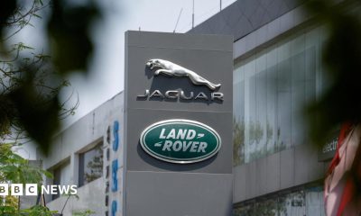 The silver leaping Jaguar emblem is on a grey pillar sign outside one of its factories with the green, oval Land Rover badge below.