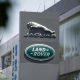 The silver leaping Jaguar emblem is on a grey pillar sign outside one of its factories with the green, oval Land Rover badge below.