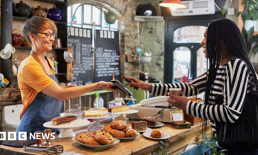 A woman pays for a coffee with her phone.
