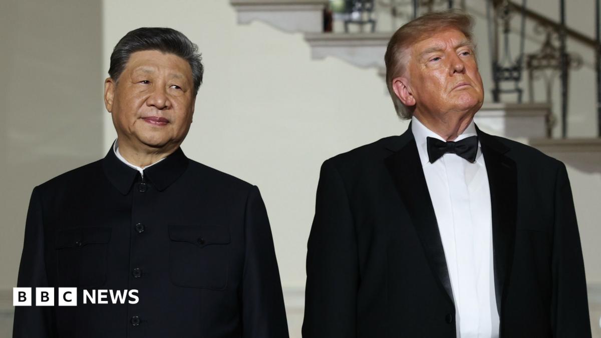 Xi Jinping and Donald Trump standing next to each other looking pensive, they are both wearing suits
