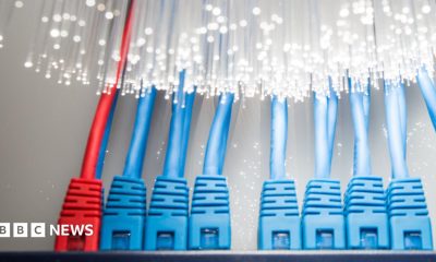 Two workers in hi-vis jackets work with bundles of cabling at a data centre project