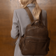 stylish professional woman wears mushroom colored suit and a dark brown backpack