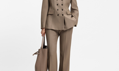 woman wears brown gabardine suit with flared pants; the pictured blazer is double-breasted with 8 buttons