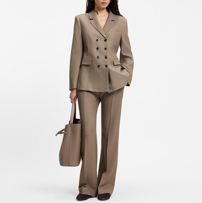 woman wears brown gabardine suit with flared pants; the pictured blazer is double-breasted with 8 buttons