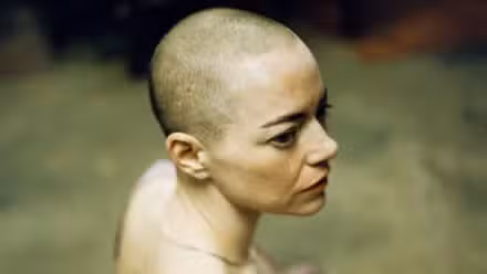 A bald Emma Stone as seen from above in Bugonia