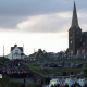 Orange Order members and their supporters gather near Drumcree Parish Church in Portadown. There are white police vehicles further down the road.