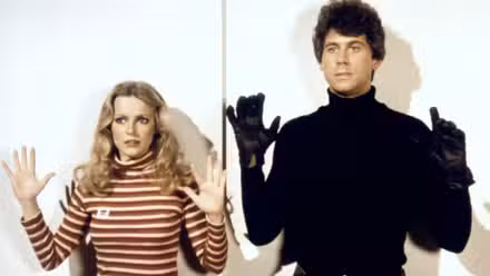 Kris (Cheryl Ladd) and Machlin (Barry Bostwich) with their hands held up in Charlie's Angels.