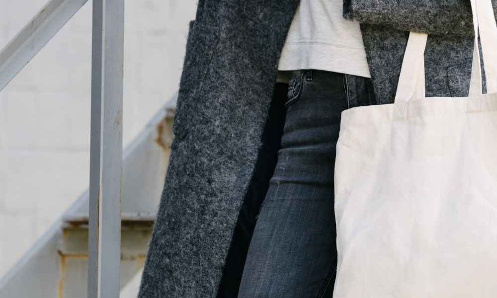 Close up of stylish woman carrying canvas tote bag