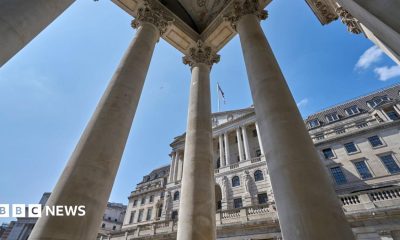 The exterior of the Bank of England with columns from a neighbouring building in the foreground.