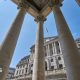 The exterior of the Bank of England with columns from a neighbouring building in the foreground.