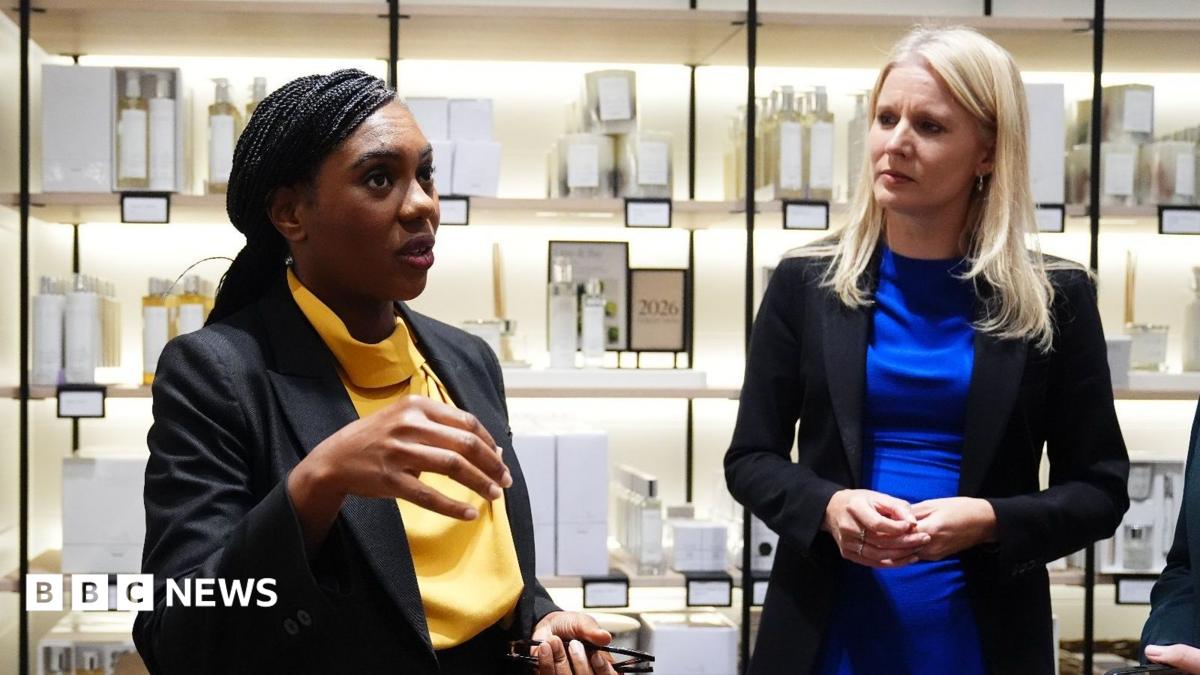 Conservative leader Kemi Badenoch and shadow culture secretary Rebecca Paul visit a shop in Bicester Village. Behind them are shelves with toiletries and candles.