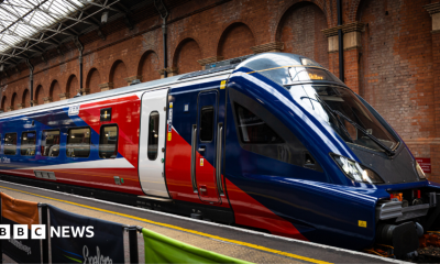 A new train stationed at Marylebone station in London. It is red, blue and white.