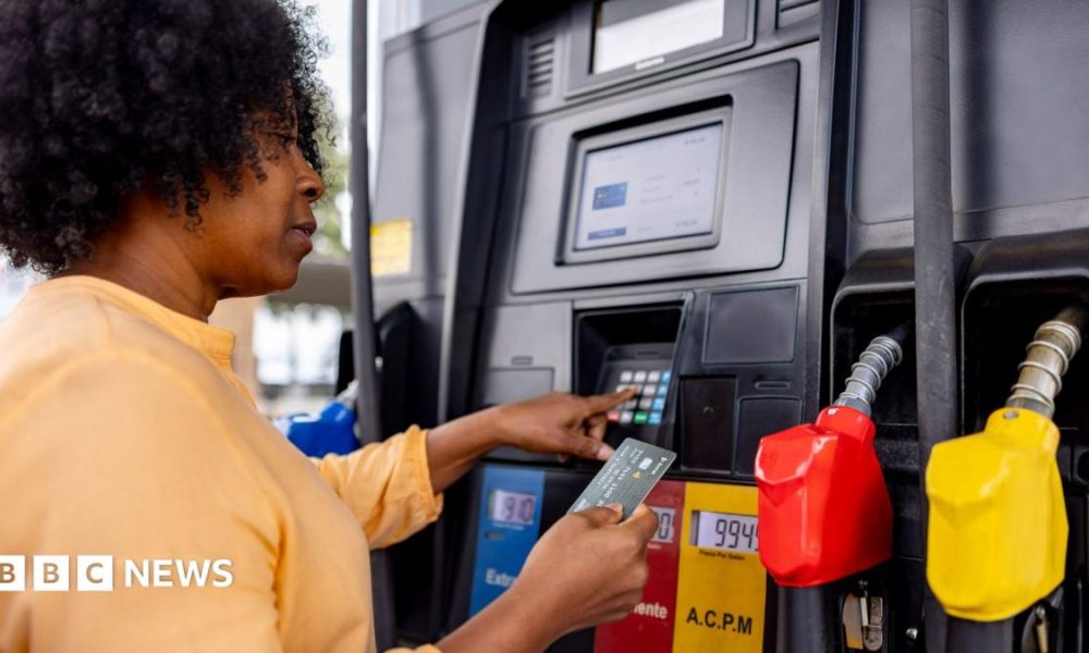 A woman pays for fuel at a gas station with her bank card