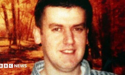 Robert Hamill with brown hair and a checked shirt smiling at the camera.