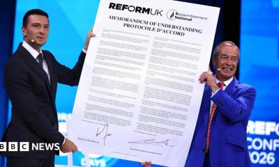 Reform UK leader Nigel Farage and National Rally President Jordan Bardella hold a large version of the proposed agreement
