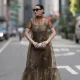 NEW YORK, NEW YORK - SEPTEMBER 12: Yana Echko seen wearing YSL oversized brown cat-eye sunglasses, Jennifer Fisher gold statement hoop earrings, Staud sheer green / brown floor-length dress with short sleeves and an all-over green floral design, Cult Gaia champagne-gold small clutch with clasp closure and strappy gold metallic heels, outside the Christian Siriano show, during New York Fashion Week, on September 12, 2025 in New York City. (Photo by Jeremy Moeller/Getty Images)