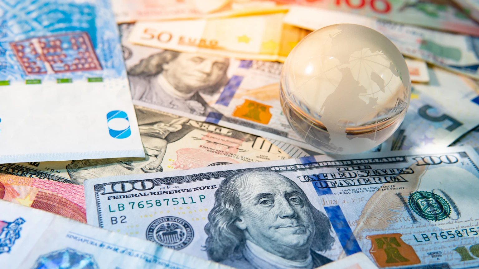 World globe crystal on various banknotes