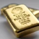 Two gold bullions weighing 250 grams each on a grey background.