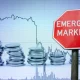 Emerging markets sign against economy background with graph and coins