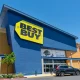 Best Buy store entrance, facade and exterior with customer car parked in front