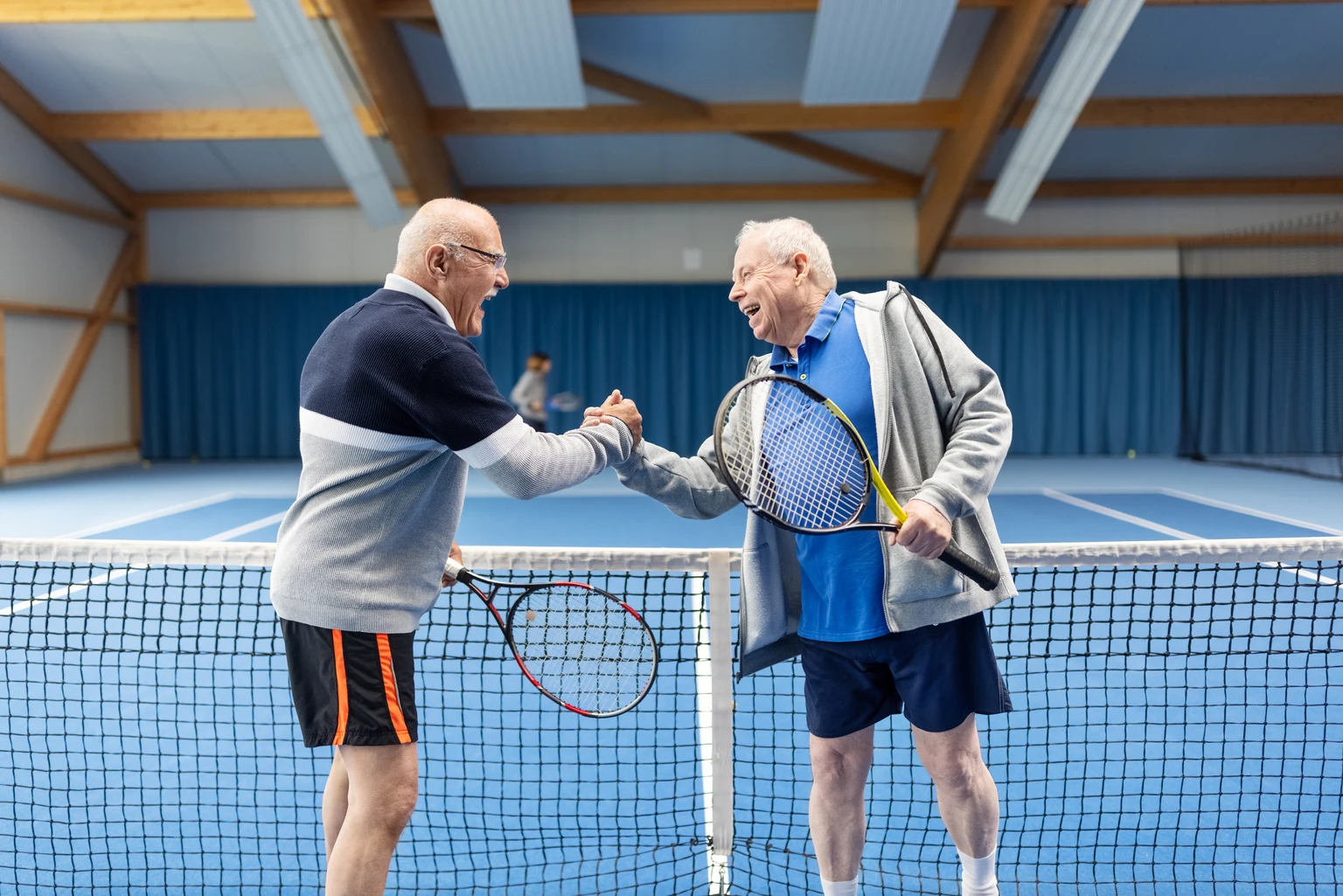 Senior tennis players greeting each other after a game of tennis