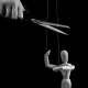 Hand cutting strings over puppet with scissors. Manipulation, negative influence, control stop concept. Overcoming addiction. Black and white