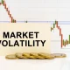 Against the background of the quotes chart, a business card with the inscription - Market Volatility