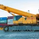 A heavy crawler crane stands on the territory of a container terminal.