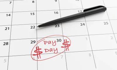 Monthly calendar with the last day circled and marked as pay day by red ball pen. Illustration of the concept of payroll of employees