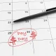 Monthly calendar with the last day circled and marked as pay day by red ball pen. Illustration of the concept of payroll of employees