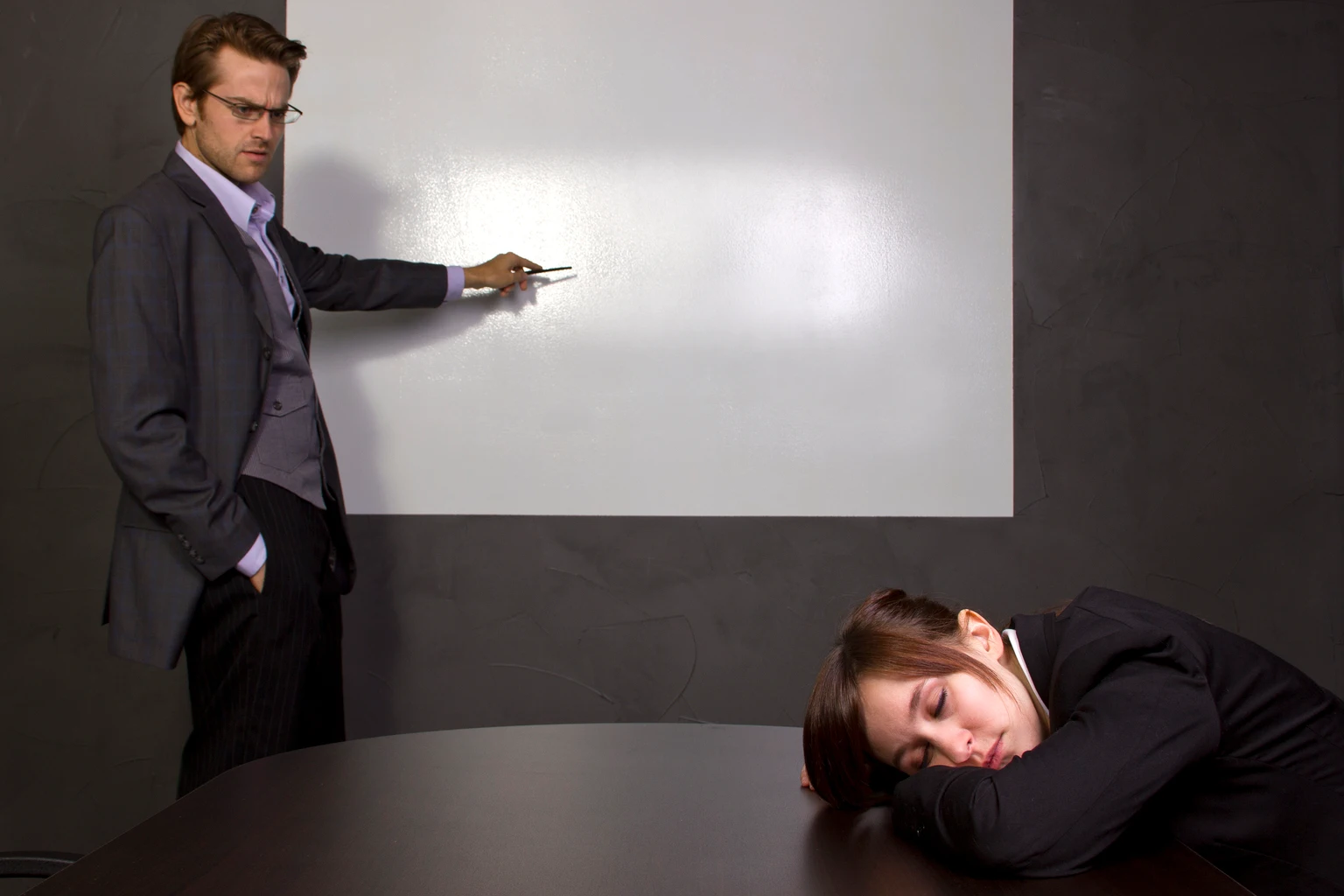 Businesswoman Sleeping in a Conference Room With a Blank Screen