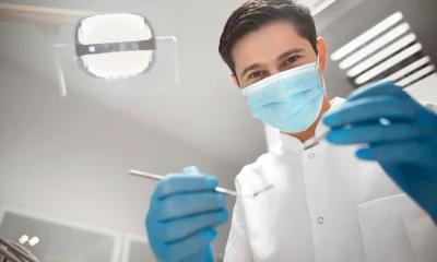 Dentist holding dental equipment in clinic