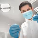 Dentist holding dental equipment in clinic