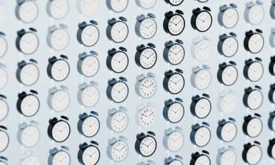Floating Alarm Clocks in a Grid Pattern with Selective Focus, Hues of Blue on a Light Blue Background