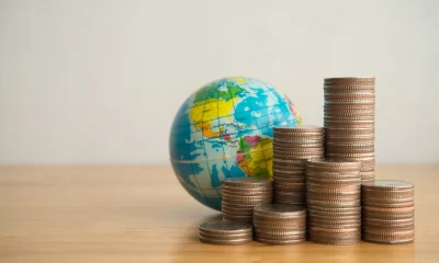 Heap stack coins and world globe with white background copy space.