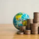Heap stack coins and world globe with white background copy space.