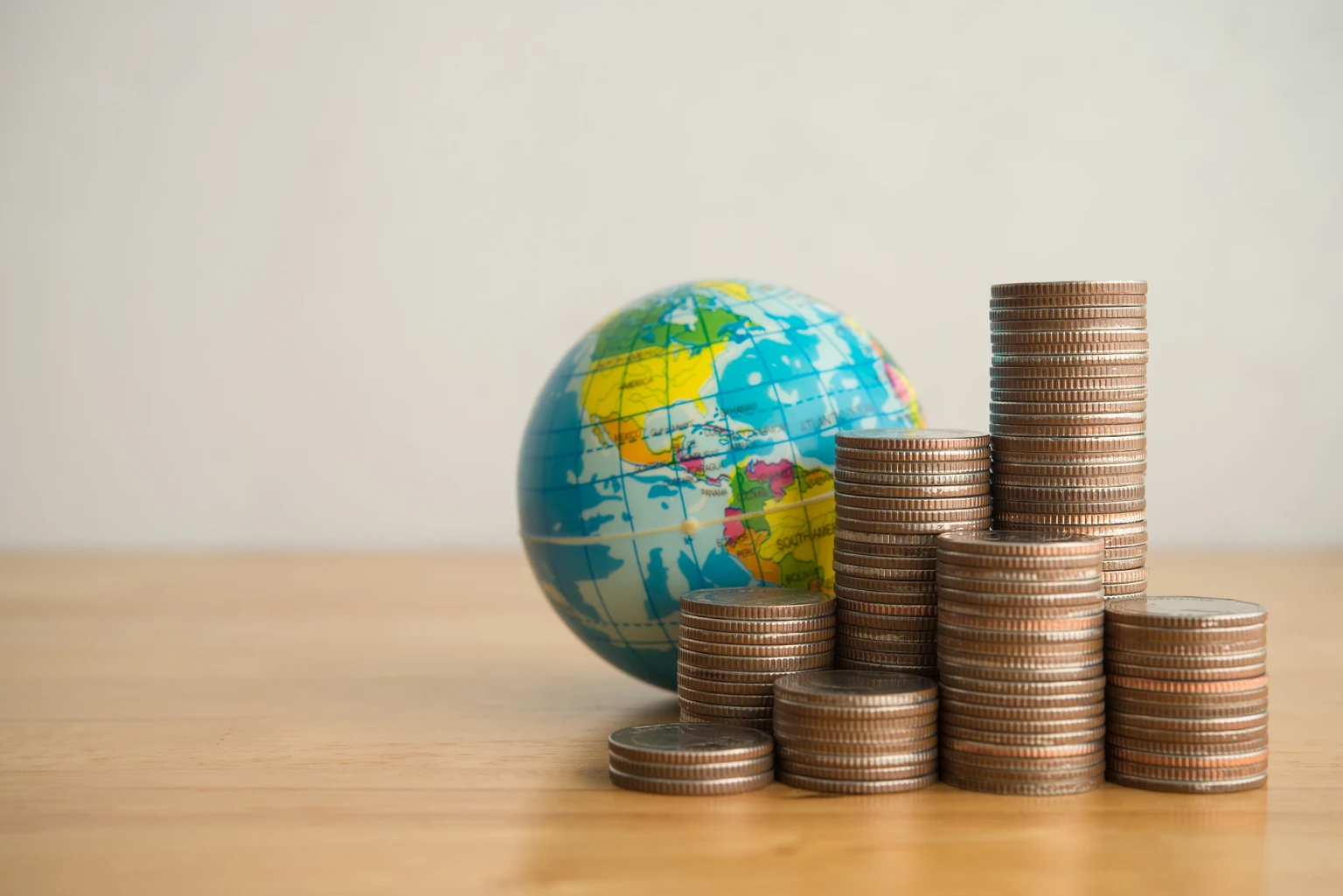 Heap stack coins and world globe with white background copy space.
