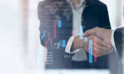 Business finance and investment background, global business and data analysis concept. Businessmen making a handshake with economic graph growth chart, business development, joint venture