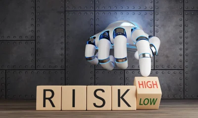 White robotic hand turning a wooden toy block to choose between high and low risk. Illustration of the concept of investment uncertainty, financial analysis and fund ratings