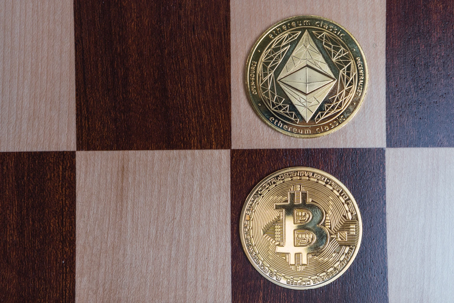 Bitcoin and ethereum classic coins competing on checkerboard