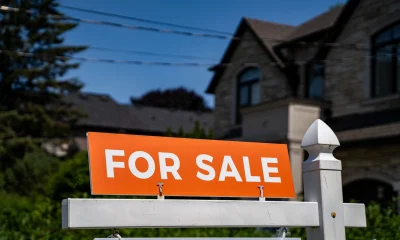 View of for sale sign in front of a house.