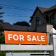View of for sale sign in front of a house.