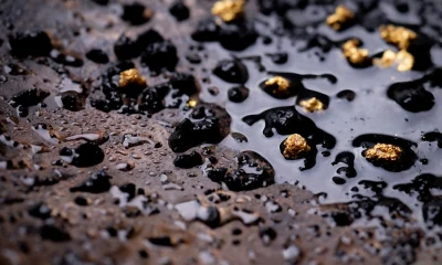 Closeup Gold on grungy wash pan with river sand. Gold digging discovery