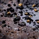 Closeup Gold on grungy wash pan with river sand. Gold digging discovery